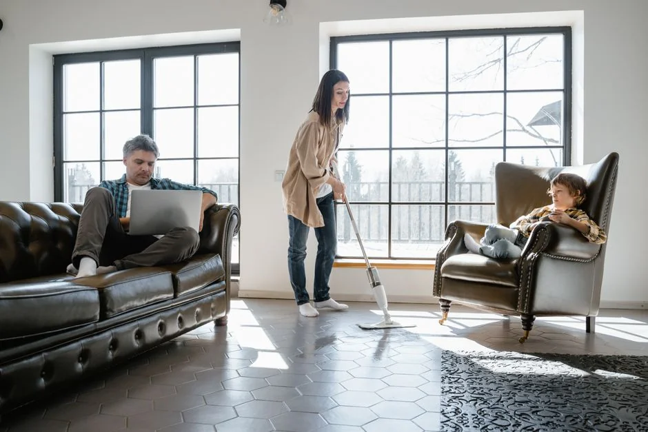 Un couple asiatique s’amuse en faisant le ménage chez eux, ce qui renforce une ambiance joyeuse.